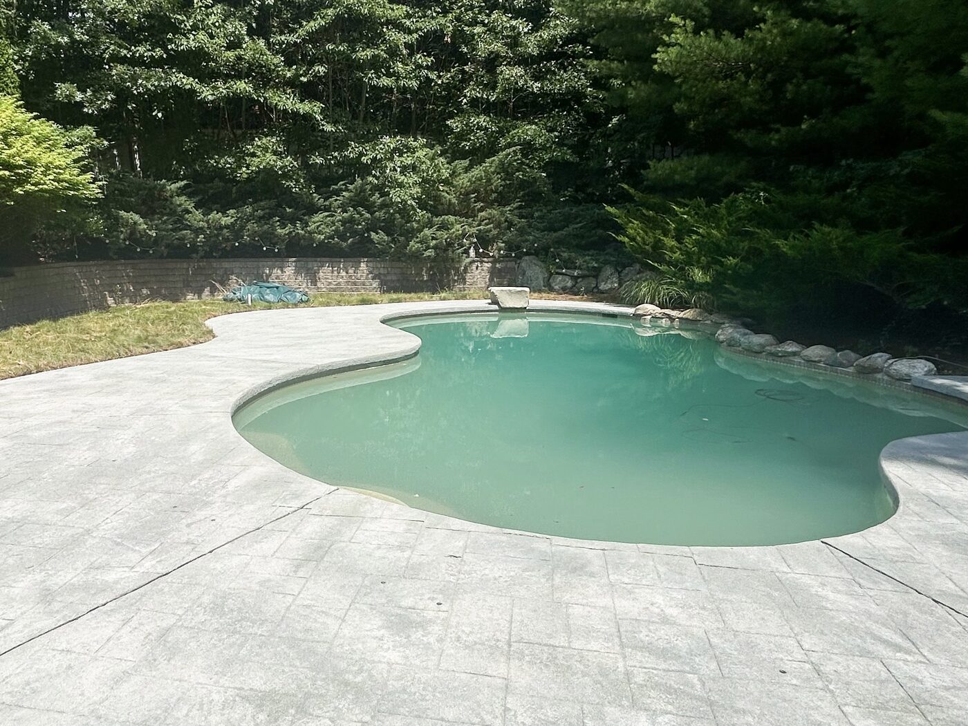 Concrete pool deck after H2WOAH cleaning — bright, clean stamped-concrete pool deck on a South Shore MA patio