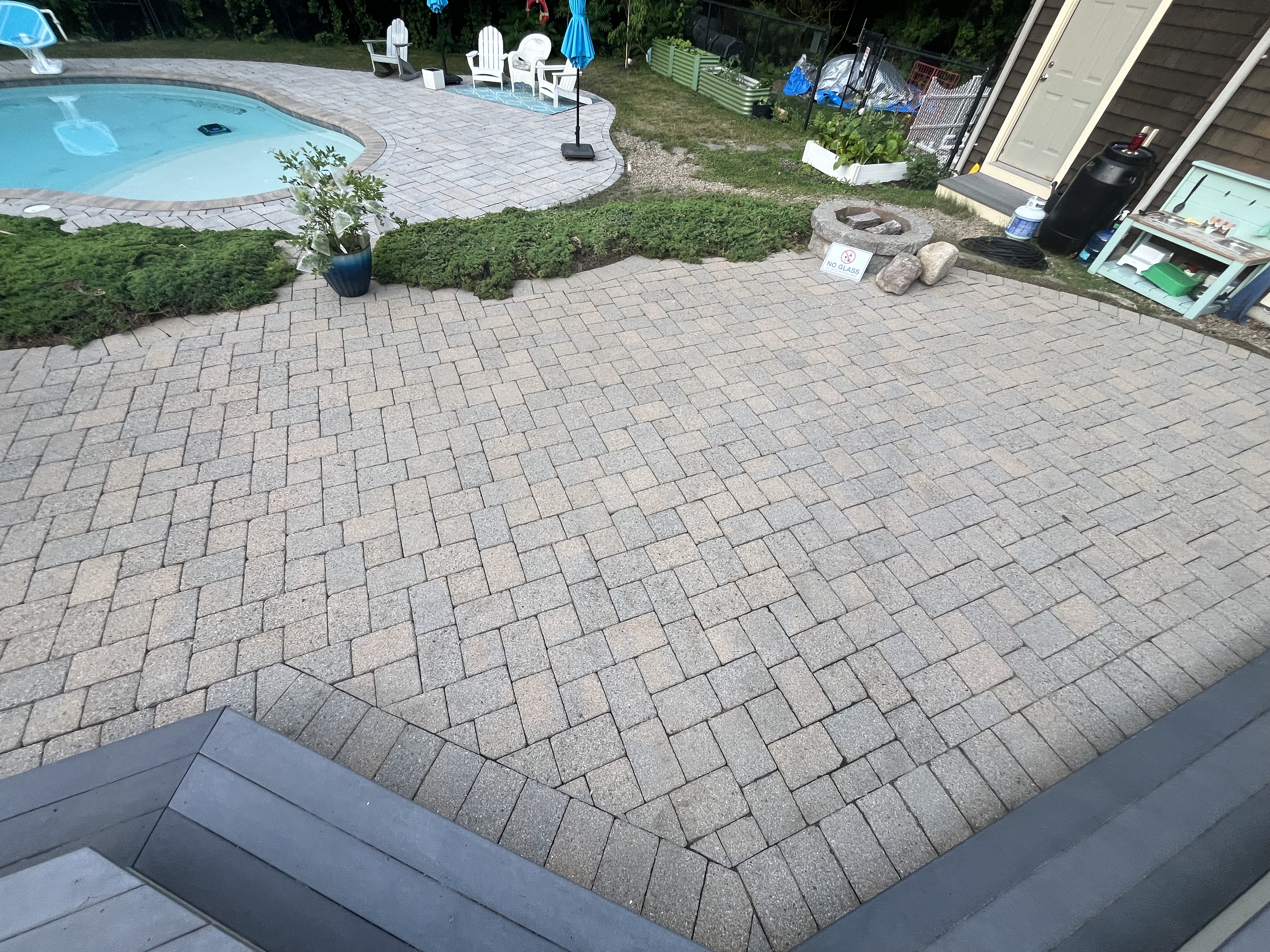Paver patio after H2WOAH cleaning in Scituate, MA — bright, clean brick paver patio beside an in-ground pool