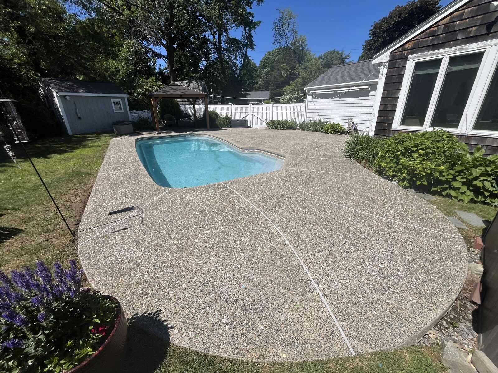 Pool deck after H2WOAH cleaning in Marshfield MA — bright, clean exposed-aggregate concrete pool deck