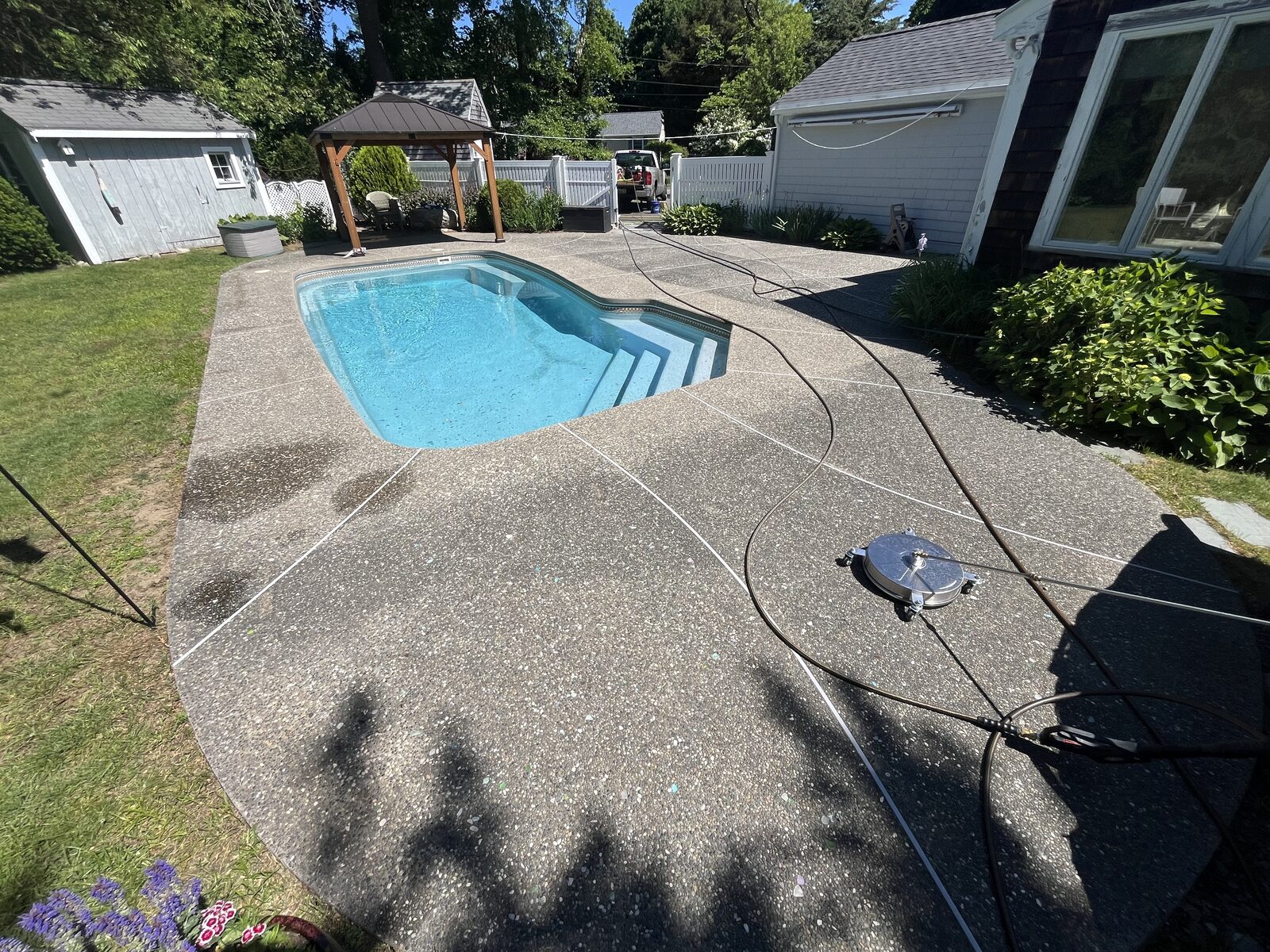 Pool deck before cleaning in Marshfield MA — dull, dirty aggregate concrete with algae and grime