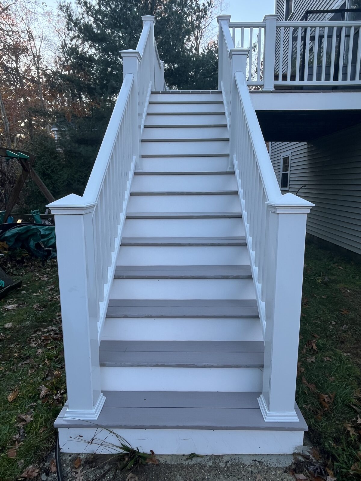 After cleaning composite deck stairs in Duxbury MA showing clean bright steps with the natural white shine restored between white railings