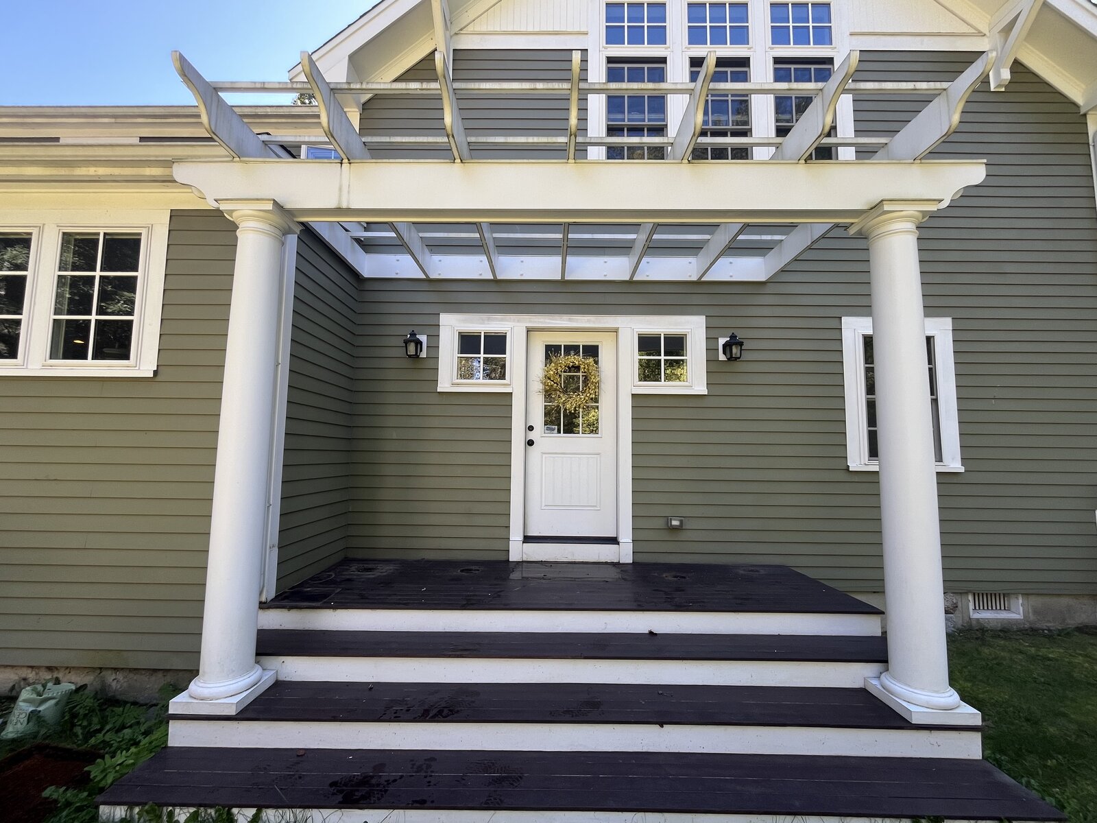 Marshfield MA front deck steps and pergola after soft washing and pressure washing showing clean green siding and a restored natural deck finish with years of green algae and mildew staining removed