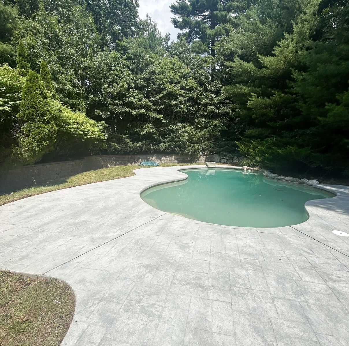 After pool deck cleaning in Marshfield MA by H2WOAH Exterior Cleaning showing a cleaner refreshed pool deck