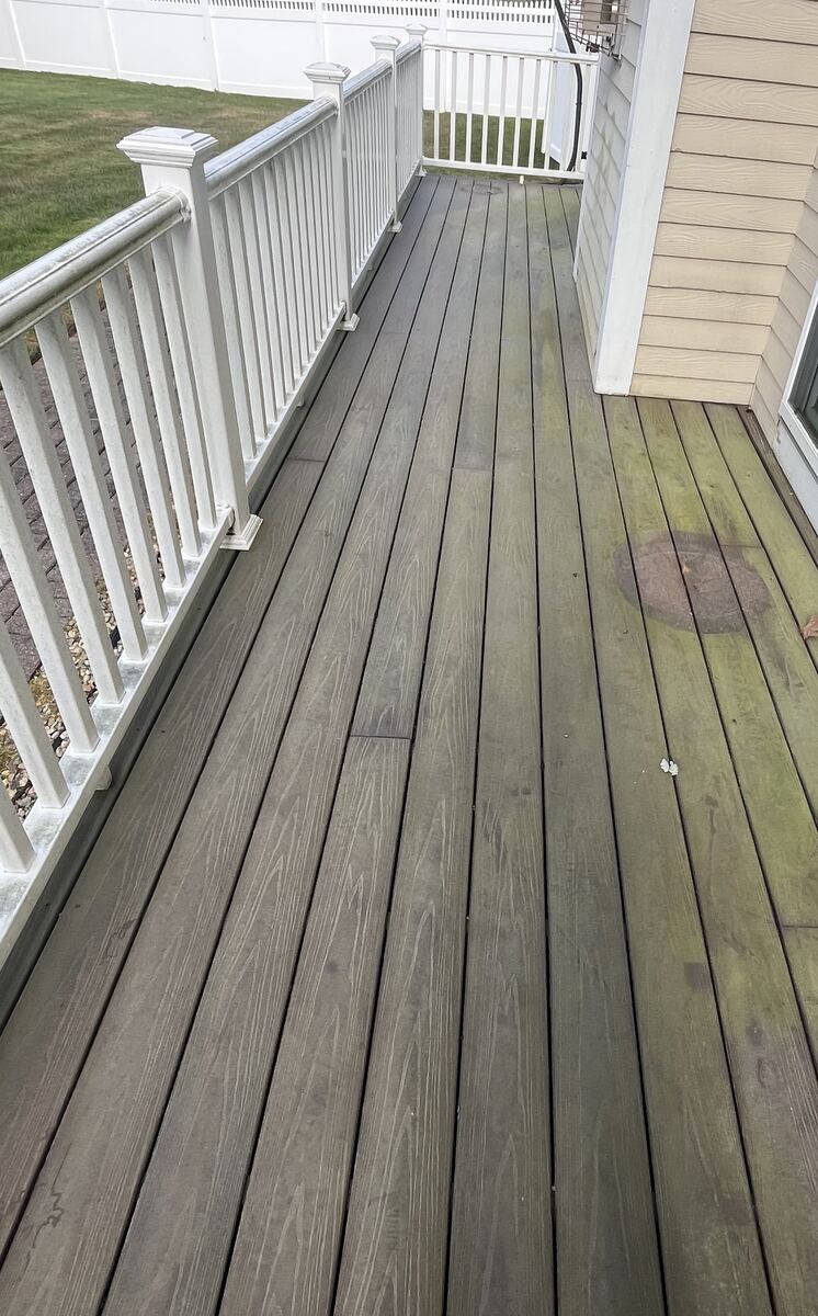 Before deck washing in Weymouth MA showing green algae and grime on composite deck boards with white railing