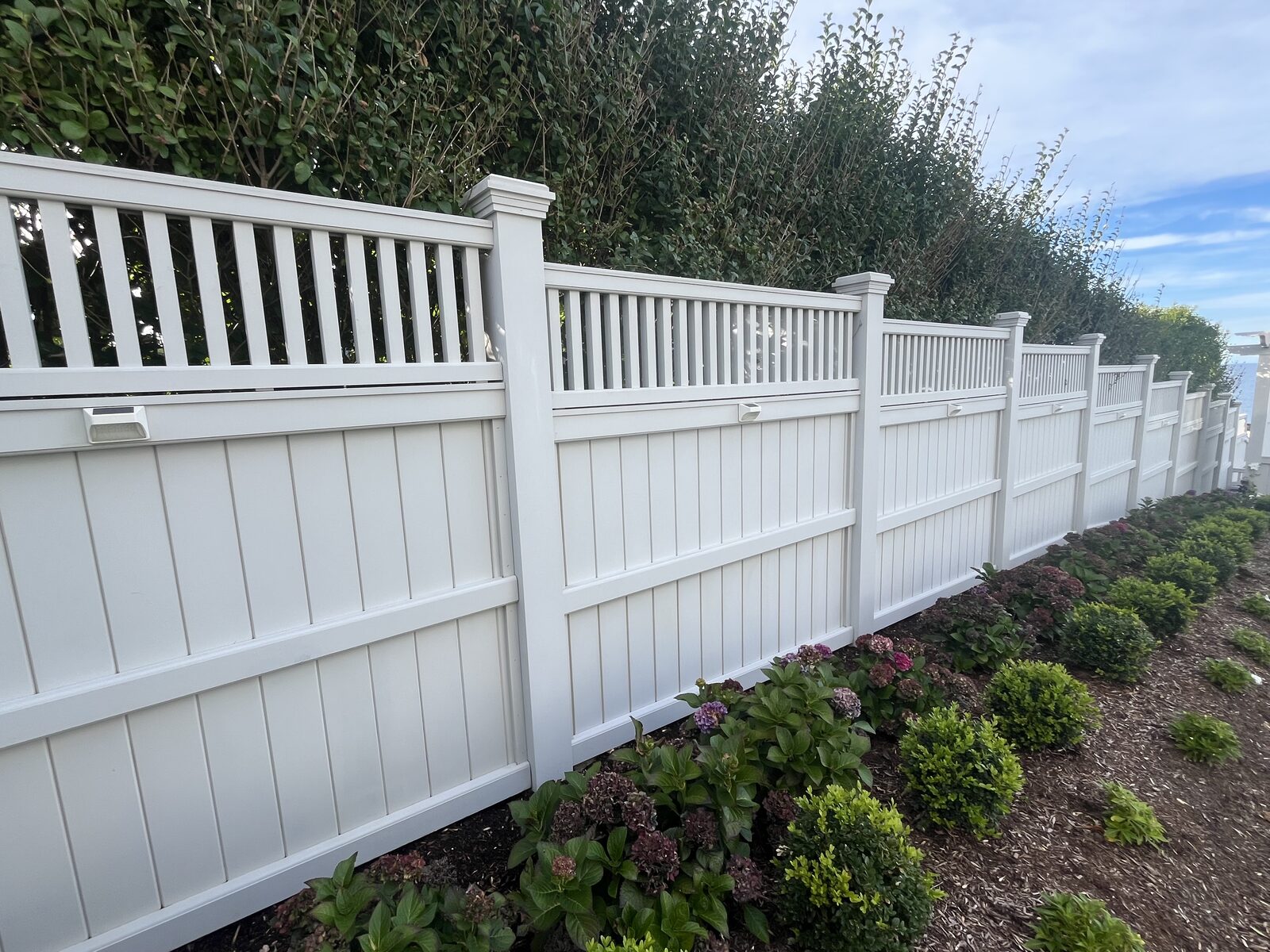 Clean white vinyl privacy fence after washing at a Cohasset MA beach property with organic buildup and salt residue removed