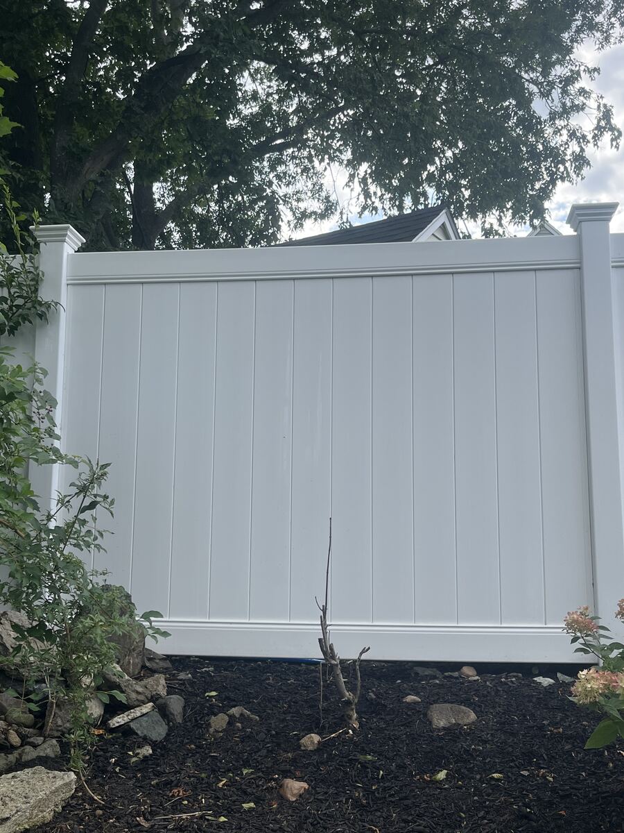 After vinyl privacy fence cleaning in Hingham MA by H2WOAH Exterior Cleaning showing bright white fence