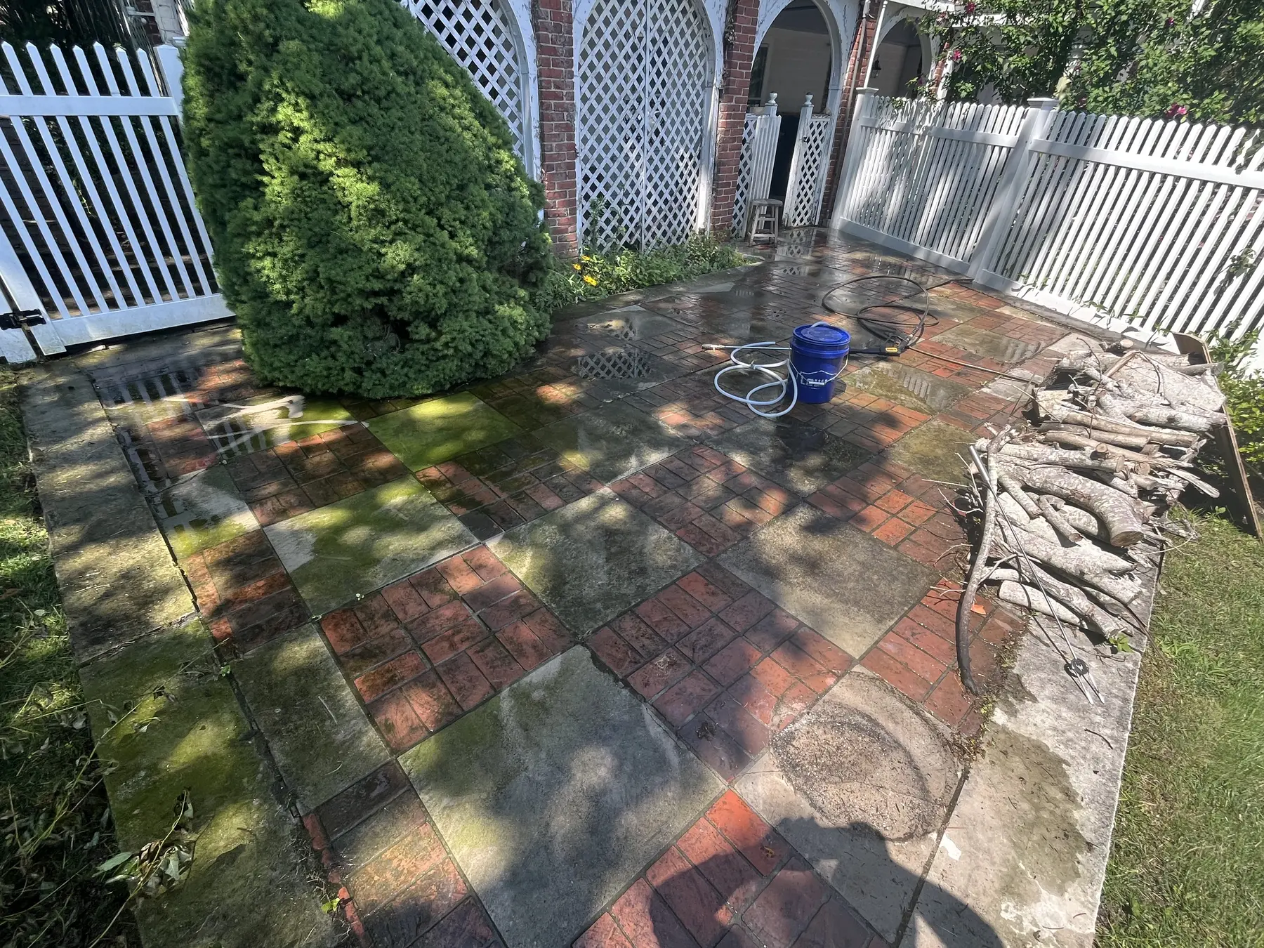 Brick patio cleaning in Plymouth MA, heavy green algae and dark organic buildup across brick and stone before cleaning