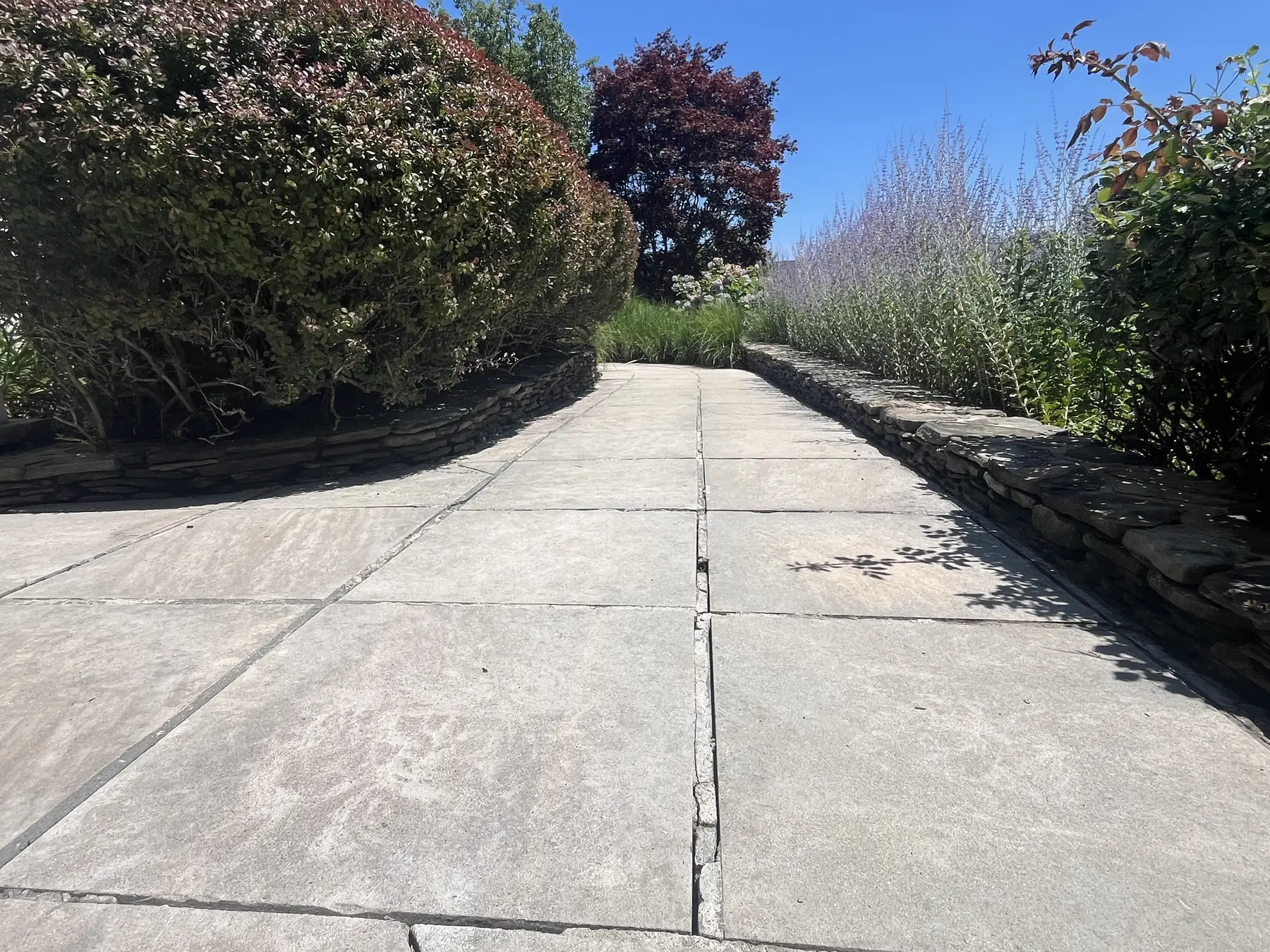 Stone pathway cleaning in Plymouth MA, bright clean stone slabs and garden walls after exterior cleaning by H2WOAH