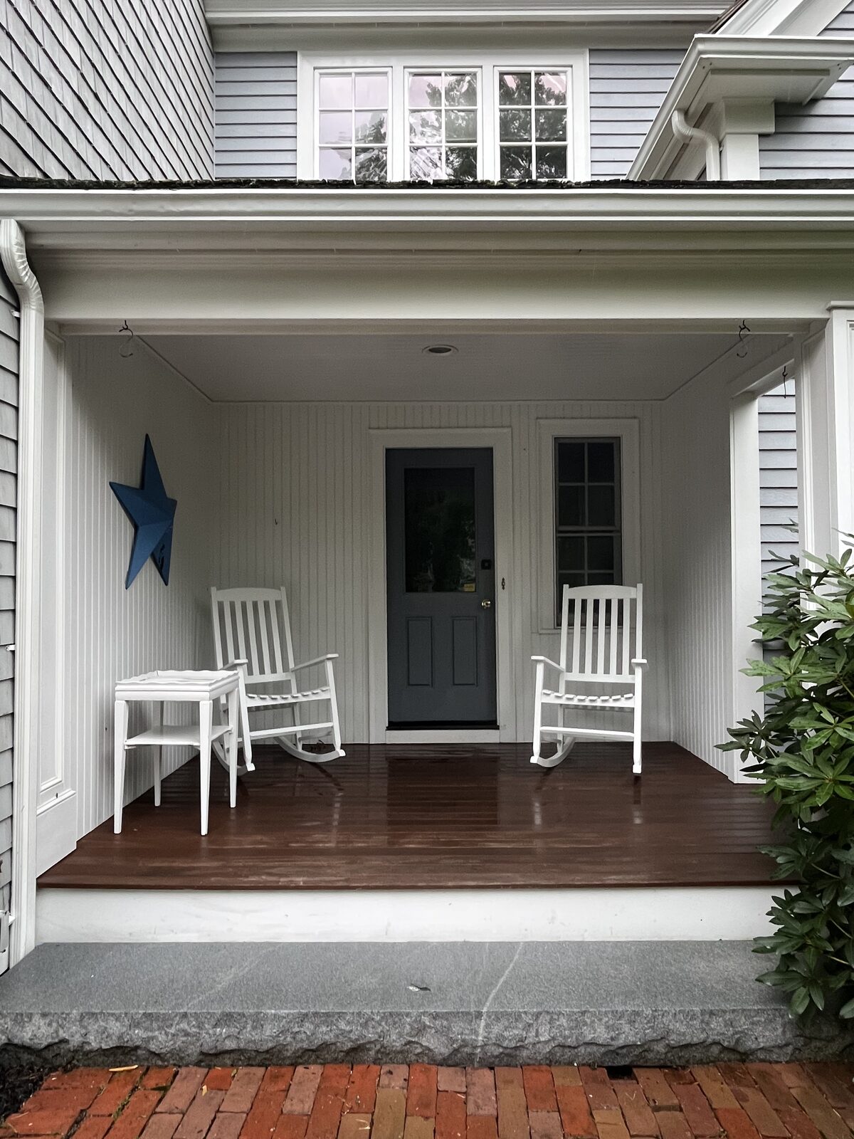 After soft wash front porch cleaning in Duxbury MA showing a bright clean porch deck steps and siding free of mildew