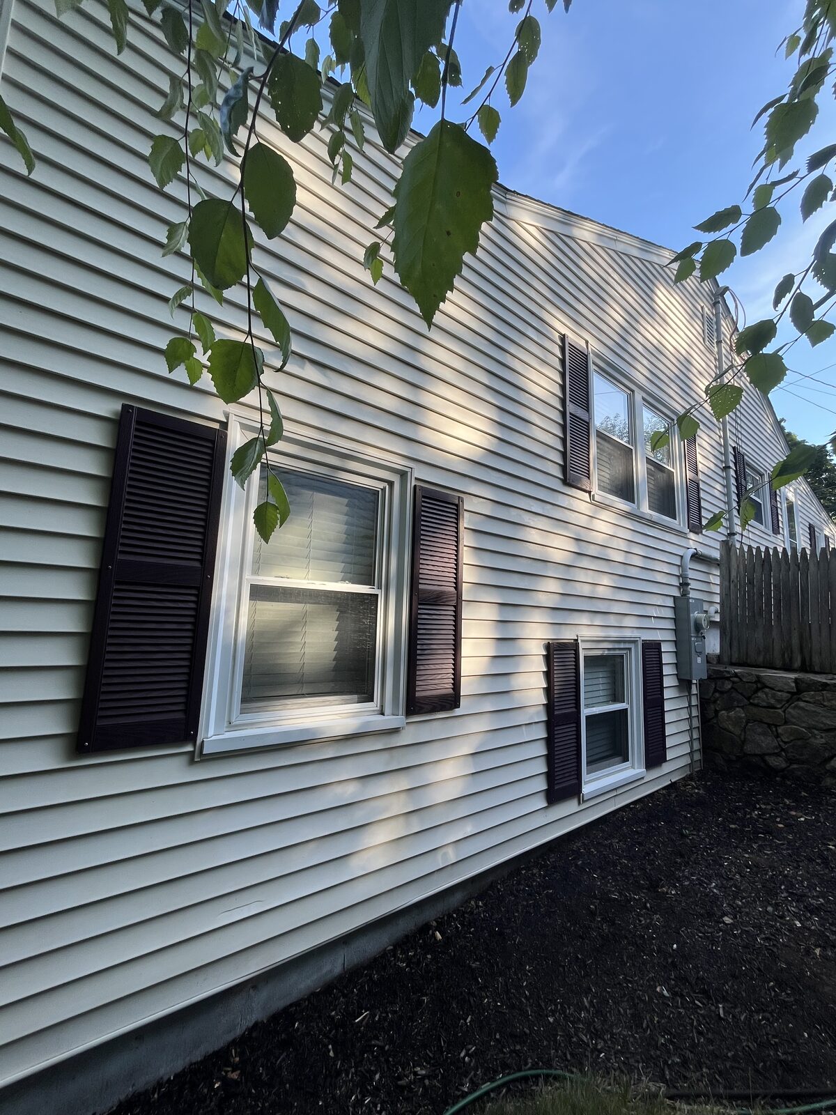 After soft wash vinyl house washing in Hingham MA showing clean mildew-free cream clapboard siding