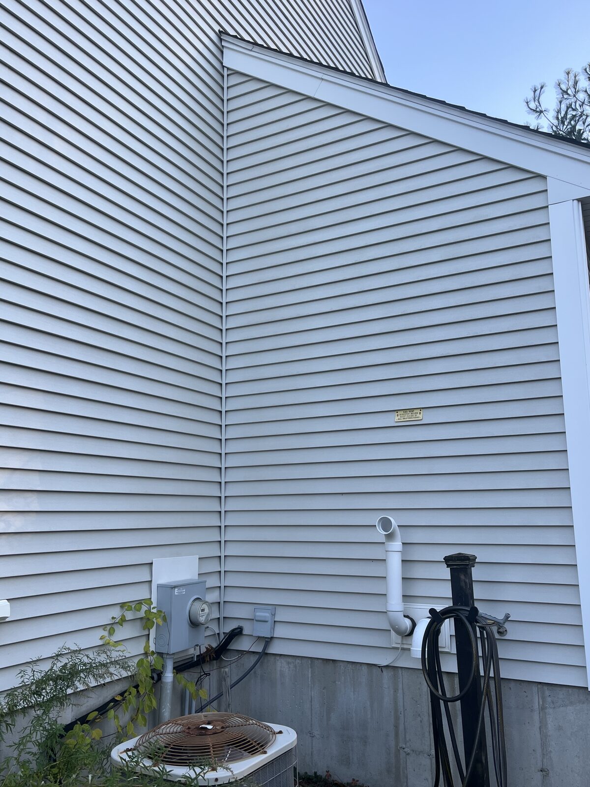 After vinyl siding wash on the north-facing side of a Weymouth MA home showing clean bright siding with the dark green buildup removed