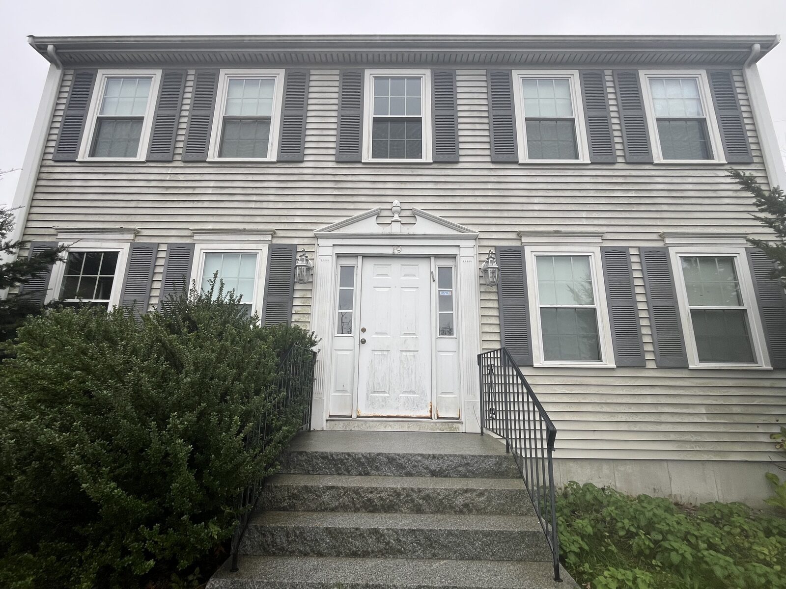 Before house washing in Weymouth MA showing organic buildup and dark streaks on vinyl siding