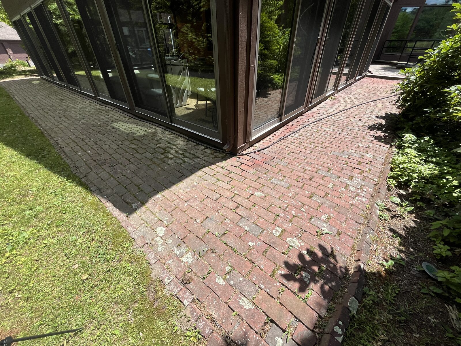 Brick walkway cleaning in Marshfield MA, weeds and grime on a brick walkway before cleaning