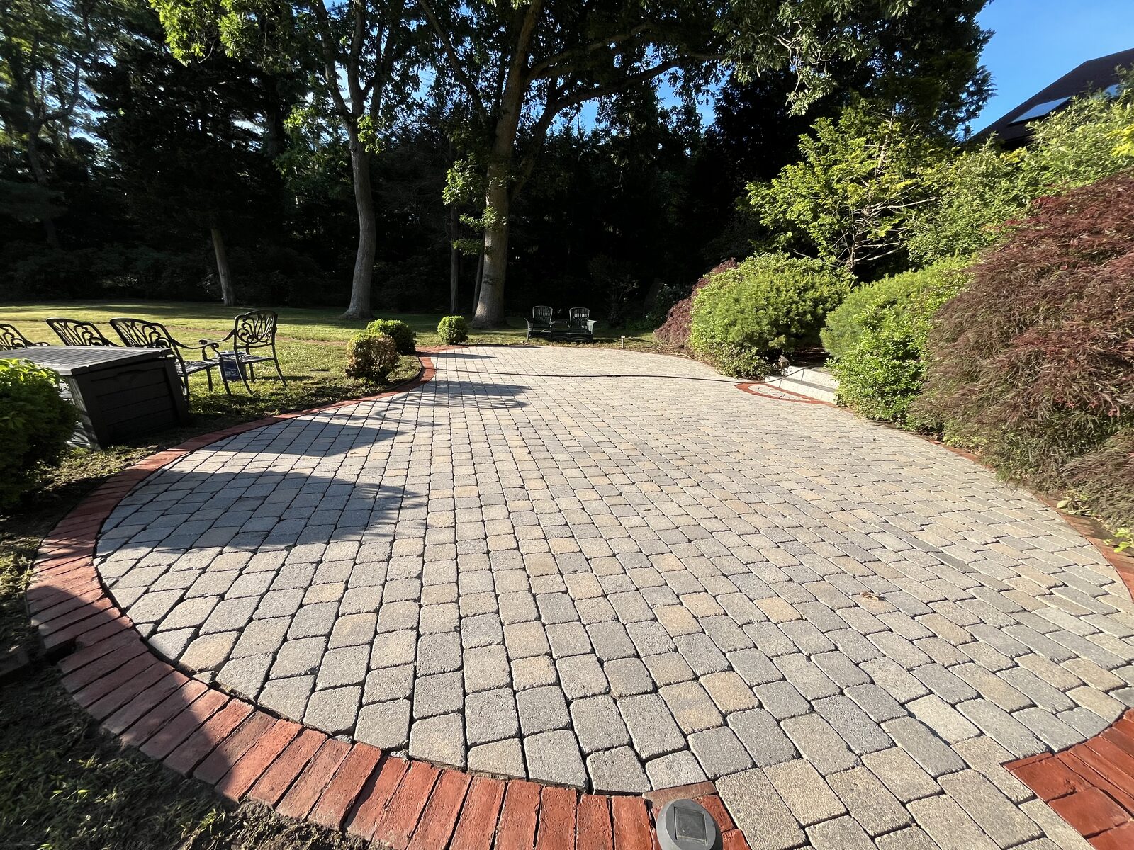 After paver patio cleaning in Marshfield MA by H2WOAH Exterior Cleaning showing bright, clean brick pavers with a red brick border