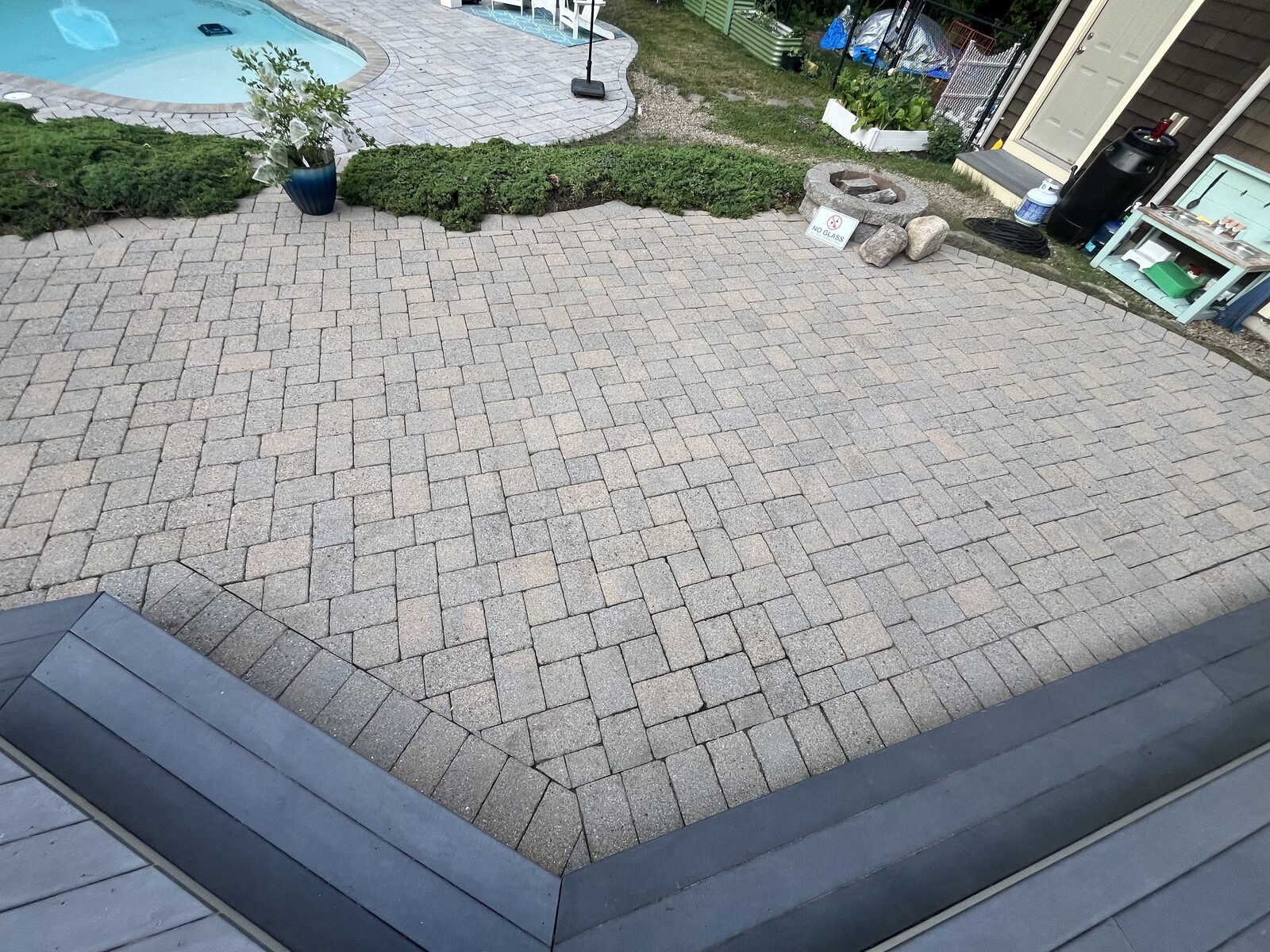 Before and after paver patio cleaning in Scituate MA by H2WOAH Exterior Cleaning, clean and even pavers near the deck after cleaning