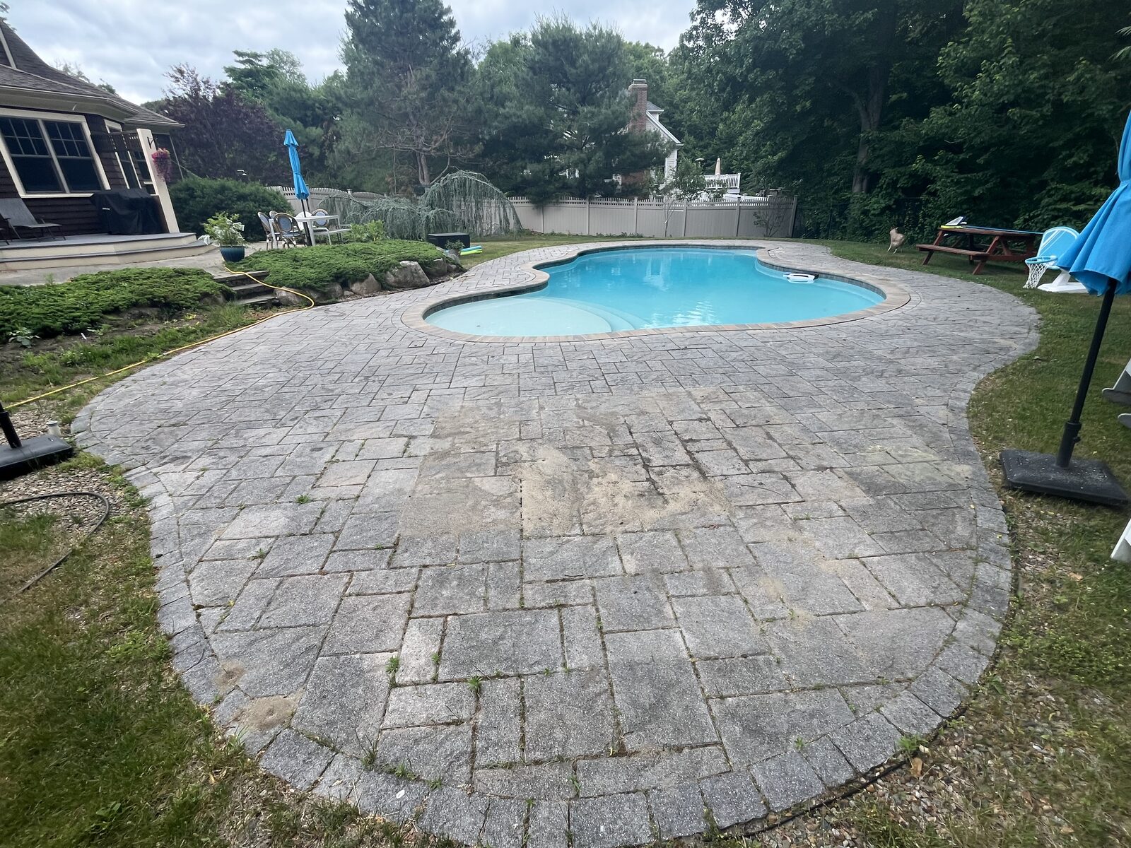 Before and after paver patio cleaning in Scituate MA by H2WOAH Exterior Cleaning, weathered pool patio before cleaning