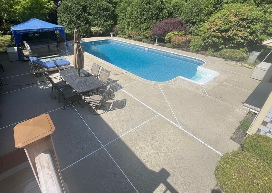 Before pool deck cleaning in Marshfield MA showing algae and grime staining the pool deck