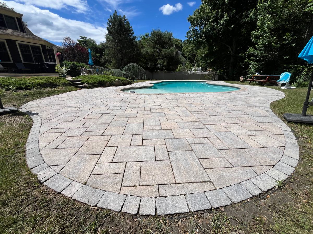 After paver pool patio cleaning in Scituate MA by H2WOAH Exterior Cleaning showing clean uniform pavers around the pool